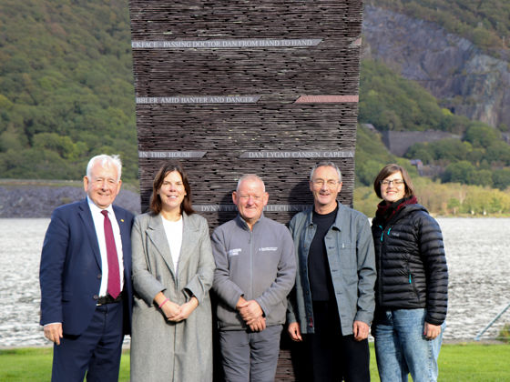 Dafydd Wigley, Cyng.Nia Jeffreys, Johnjo Jones, Howard Bowcott, Gwenlli Haf Evans o flaen cerflun llechi llanberis